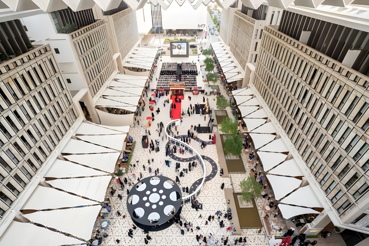 High-angle view of people walking through the Barahat Msheireb courtyard with retractable white awnings in Doha, Qatar.