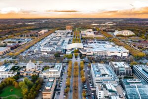 Aerial view of Milton Keynes city center featuring the shopping district, grid roads, and autumn trees at sunset.