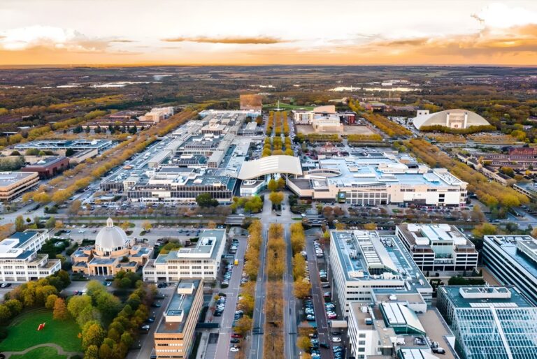 Aerial view of Milton Keynes city center featuring the shopping district, grid roads, and autumn trees at sunset.