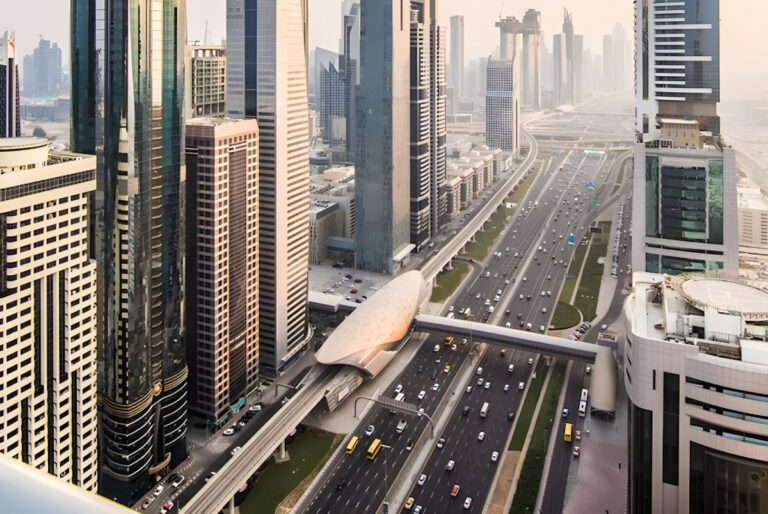 Aerial view of Sheikh Zayed Road in Dubai featuring heavy traffic, skyscrapers, and a Dubai Metro station.