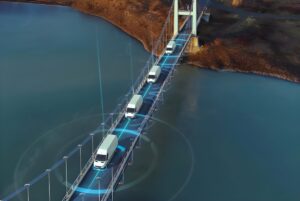 Aerial view of white vans crossing a suspension bridge with blue digital connectivity graphics and data rings.
