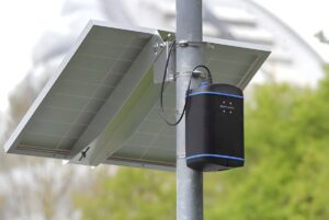 An EarthSense Zephyr air quality sensor and solar panel mounted to a metal utility pole.