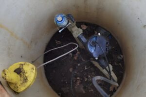 A FIDO AI acoustic sensor and blue water meter installed inside a concrete utility pit.