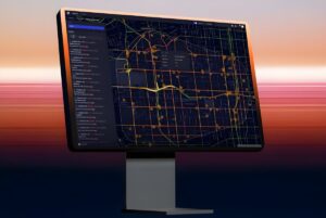 Computer monitor displaying the Flow Labs traffic management platform with a digital map of city road networks.