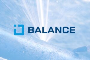 Water spraying from a high-pressure leak in a metal pipe with the GWF BALANCE logo overlaid.