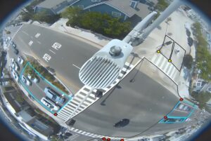 Fisheye view from a smart traffic camera monitoring an intersection with digital bounding boxes around vehicles.