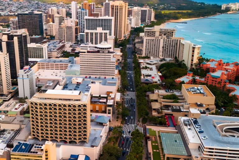 Aerial view of high-rise buildings and traffic on Kalakaua Avenue along the Waikiki coastline in Honolulu, Hawaii.