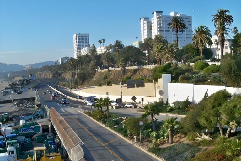 High-angle view of traffic on the Pacific Coast Highway in Santa Monica with palm trees and coastal buildings.