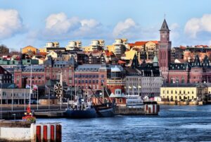 Skyline of Helsingborg, Sweden, featuring the harbor, historic brick architecture, and the Kärnan tower under a blue sky.