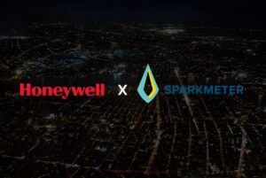 Honeywell and SparkMeter logos overlaid on an aerial view of a city grid at night with illuminated streets.