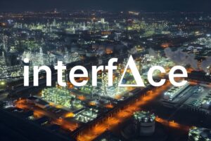 The Interface company logo overlaid on an aerial night view of a brightly lit industrial energy refinery complex.