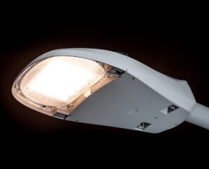 Close-up of an illuminated LEOTEK LED cobra head street light fixture against a black background.
