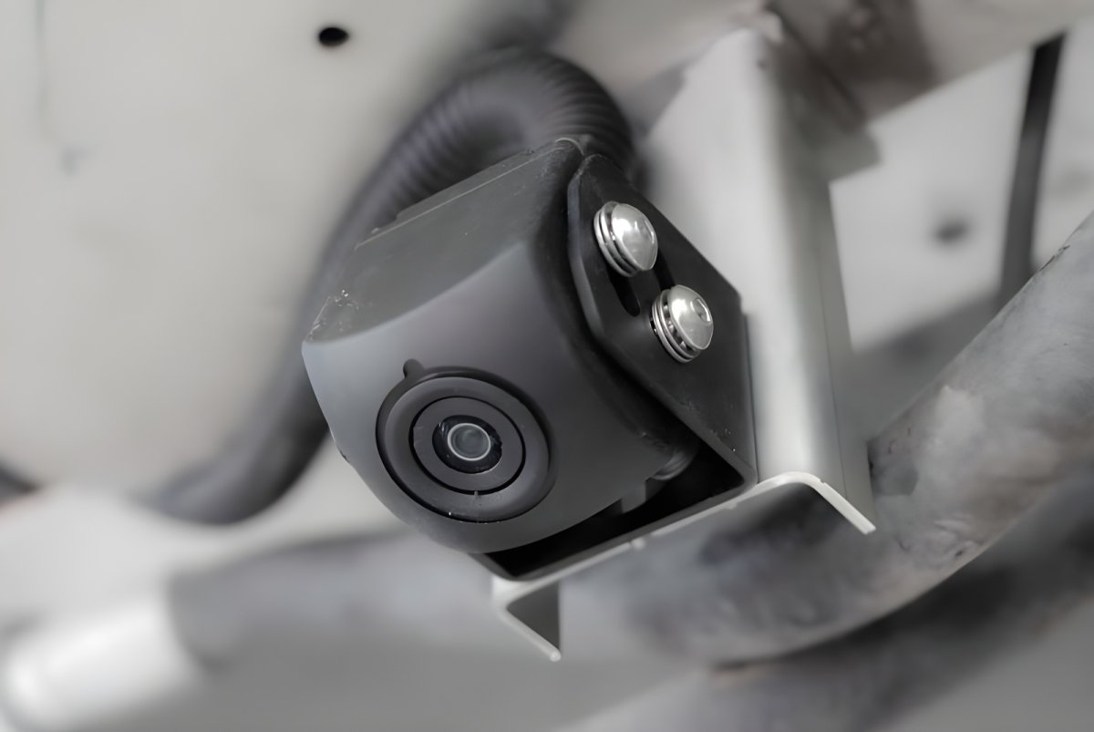 Close-up of a black Lixo computer vision camera mounted on a metal bracket of a waste collection vehicle.