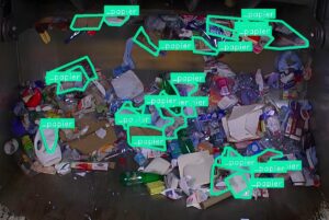 LIXO AI computer vision software identifying and tagging paper waste with green bounding boxes inside a refuse truck.