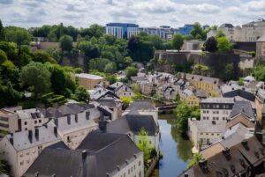 High-angle view of the Grund district in Luxembourg City featuring historic stone buildings along the Alzette River.