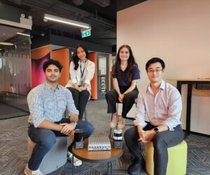Four Kodifly team members pose in a modern office with LiDAR sensors and hardware displayed on a central coffee table.