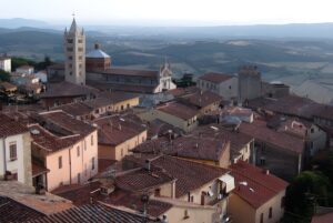 High-angle view of the historic Massa Marittima skyline featuring the Cathedral of Saint Cerbonius and terracotta rooftops.