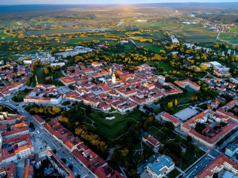 Aerial drone view of Karlovac, Croatia, featuring the historic star-shaped fortress city center and red-roofed buildings.