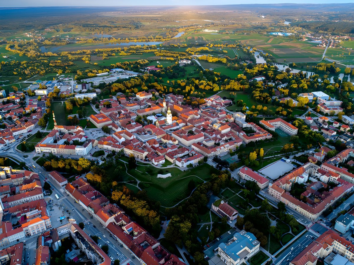 Aerial drone view of Karlovac, Croatia, featuring the historic star-shaped fortress city center and red-roofed buildings.