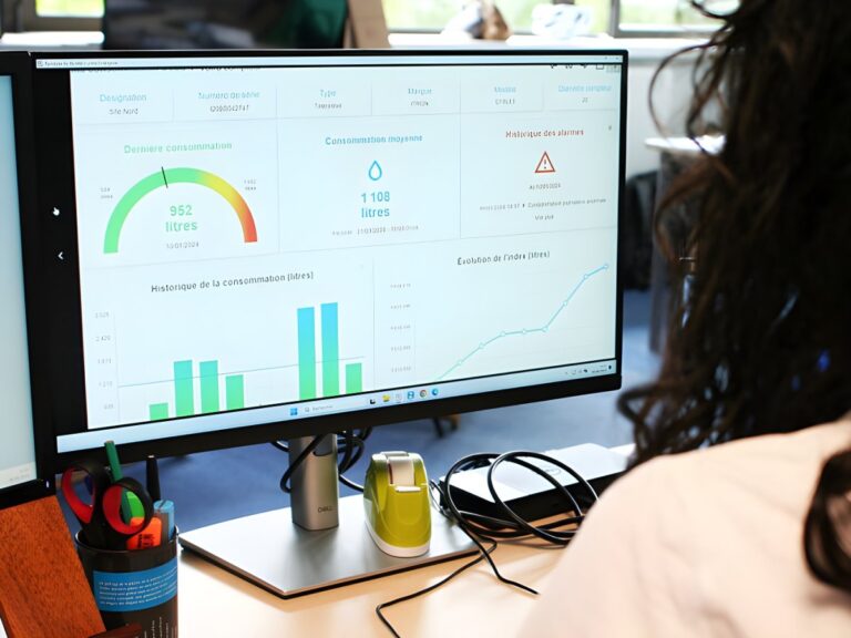 A person views a digital dashboard on a computer monitor displaying water consumption charts and utility data analytics.
