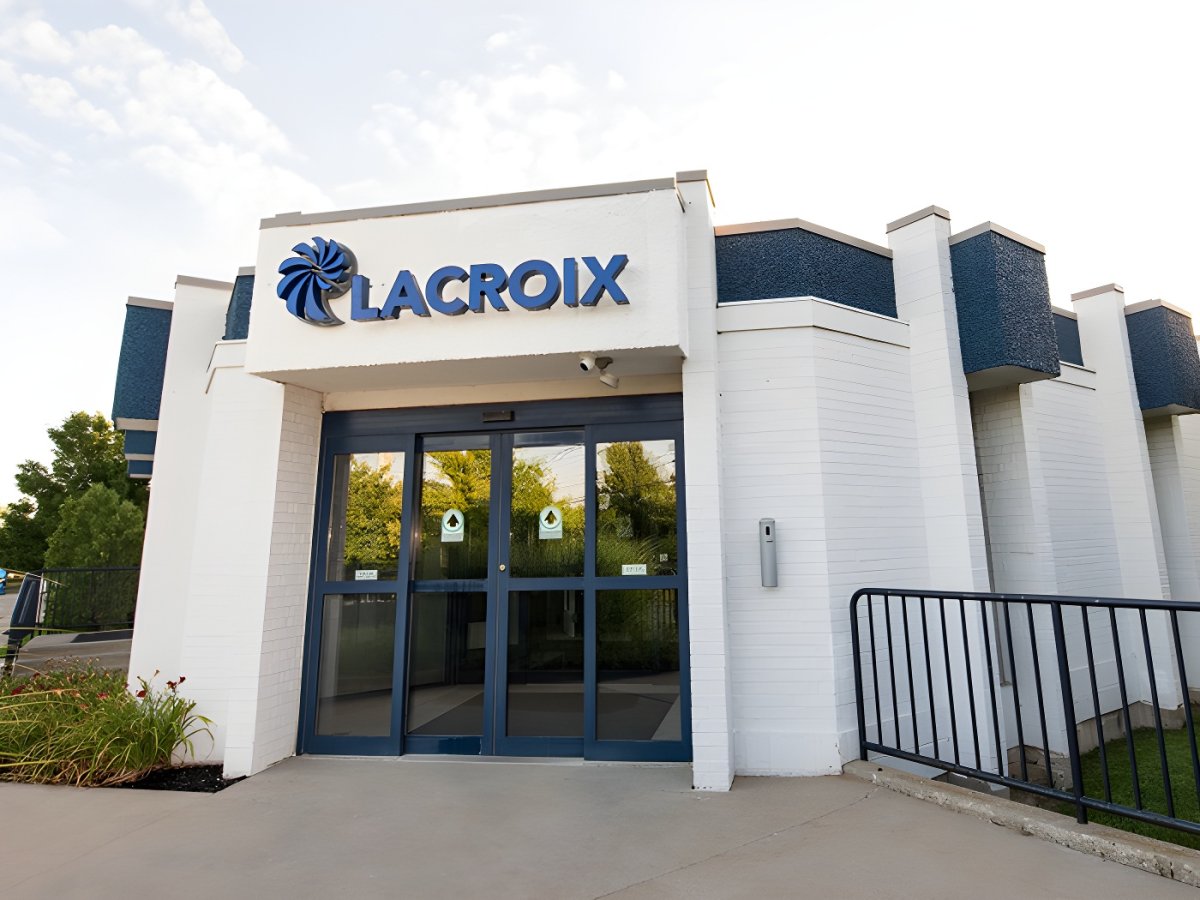 Exterior of a white and blue Lacroix office building featuring a glass sliding door entrance and company signage.