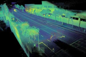 High-resolution 3D lidar point cloud scan of a multi-lane city street with buildings, trees, and sidewalks.