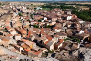 High-angle aerial view of a rural Spanish town with terracotta tile roofs in Soria Province.