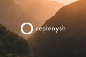 White Replenysh logo overlaid on a landscape of forested mountains at sunset.