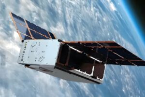 A Sateliot nanosatellite with deployed solar panels orbits above Earth's atmosphere and cloud layer.