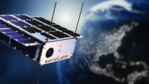 A Sateliot nanosatellite with solar panels and antennas orbiting above a blurred Earth with city lights.