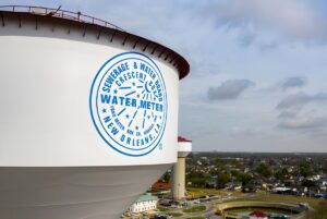 Sewerage and Water Board of New Orleans water tower overlooking a treatment facility and residential neighborhood.