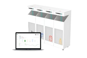 Four Smartbin.io recycling stations for paper, plastic, cans, and glass next to a laptop displaying a data dashboard.