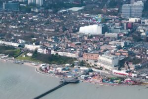Aerial view of Southend-on-Sea coastline featuring the pier, amusement park, and urban residential developments.