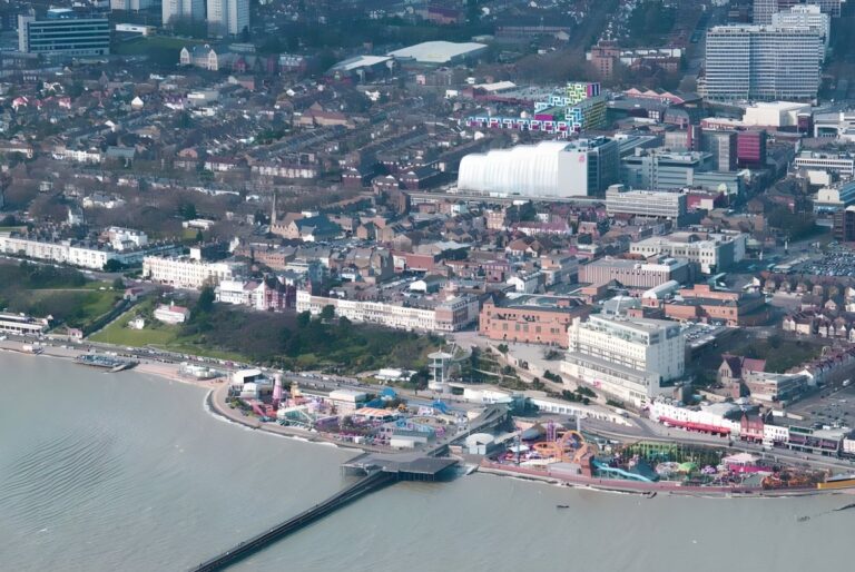 Aerial view of Southend-on-Sea coastline featuring the pier, amusement park, and urban residential developments.