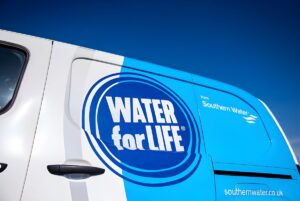 Close-up of a white Southern Water utility van featuring the Water for Life logo against a clear blue sky.
