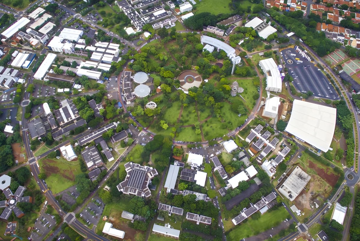 Aerial view of the circular Unicamp campus layout in Brazil featuring academic buildings, parking lots, and green spaces.