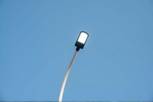 Low angle view of an illuminated LED streetlight against a clear blue sky.