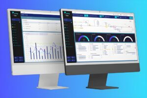 Two computer monitors displaying The Turing Company water management software dashboards with data charts and system maps.