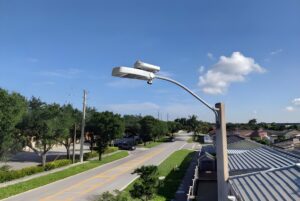 Ubicquia smart city sensor and AI camera mounted on a street light overlooking a suburban road.