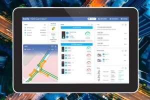 Tablet displaying the Iteris V2X Connect traffic management dashboard over an aerial city background.