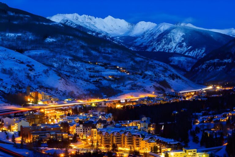 Elevated night view of the illuminated Town of Vail nestled in a snow-covered mountain valley.