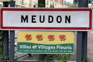 Meudon city entrance sign above a Villes et Villages Fleuris quality of life label on a suburban street.