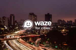 The Waze for Cities logo overlaid on a long-exposure night photograph of highway traffic light trails and city buildings.