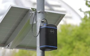 An EarthSense Zephyr air quality sensor and solar panel mounted to a metal utility pole.