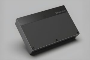A rectangular black Bitsensing traffic sensor device angled on a gray surface.