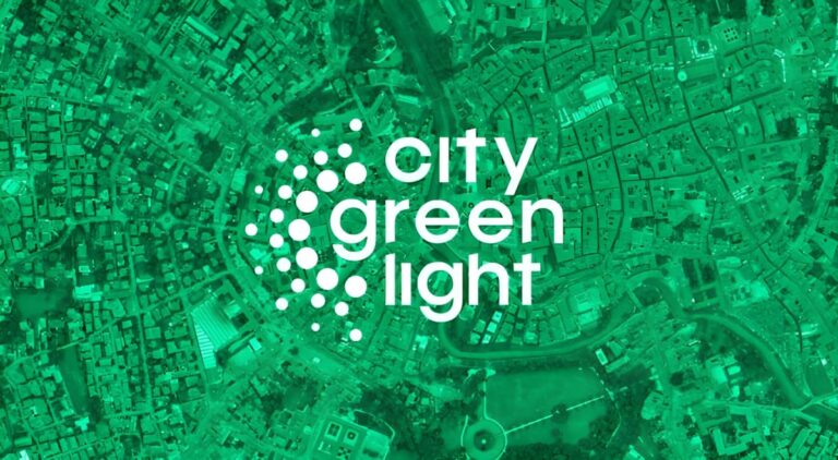 City Green Light logo centered over a green-tinted aerial satellite view of a dense urban city grid.