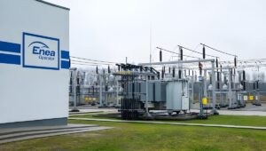 Outdoor electrical substation with transformers and power lines next to a building featuring the Enea Operator logo.