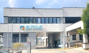 Exterior view of an Acinque office building with a gated entrance and company signage on the facade.