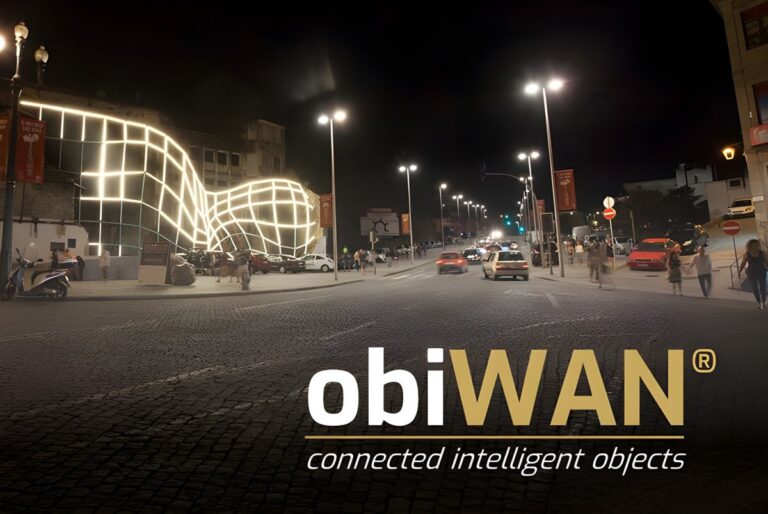 Nighttime city street with illuminated smart lighting poles and an obiWAN logo overlay.