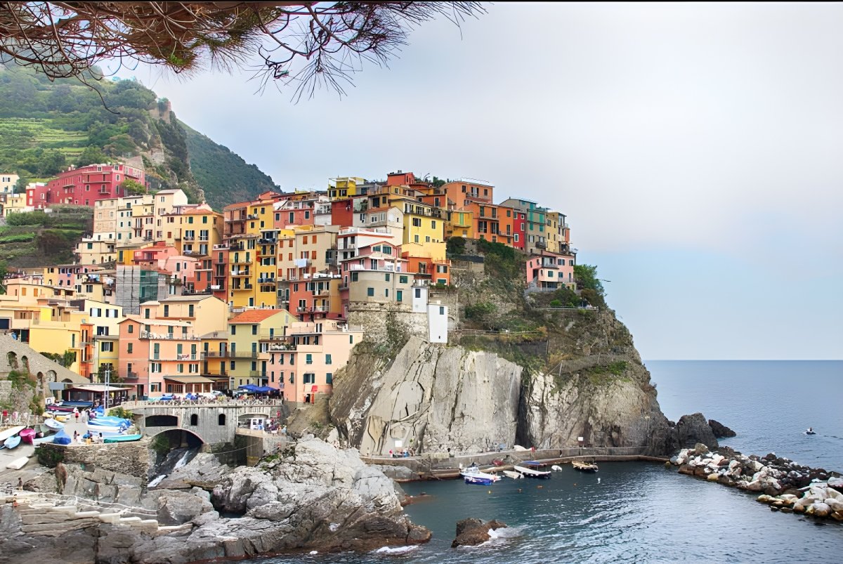 Colorful buildings of Manarola village clustered on a rocky cliff overlooking the Ligurian Sea in Cinque Terre, Italy.